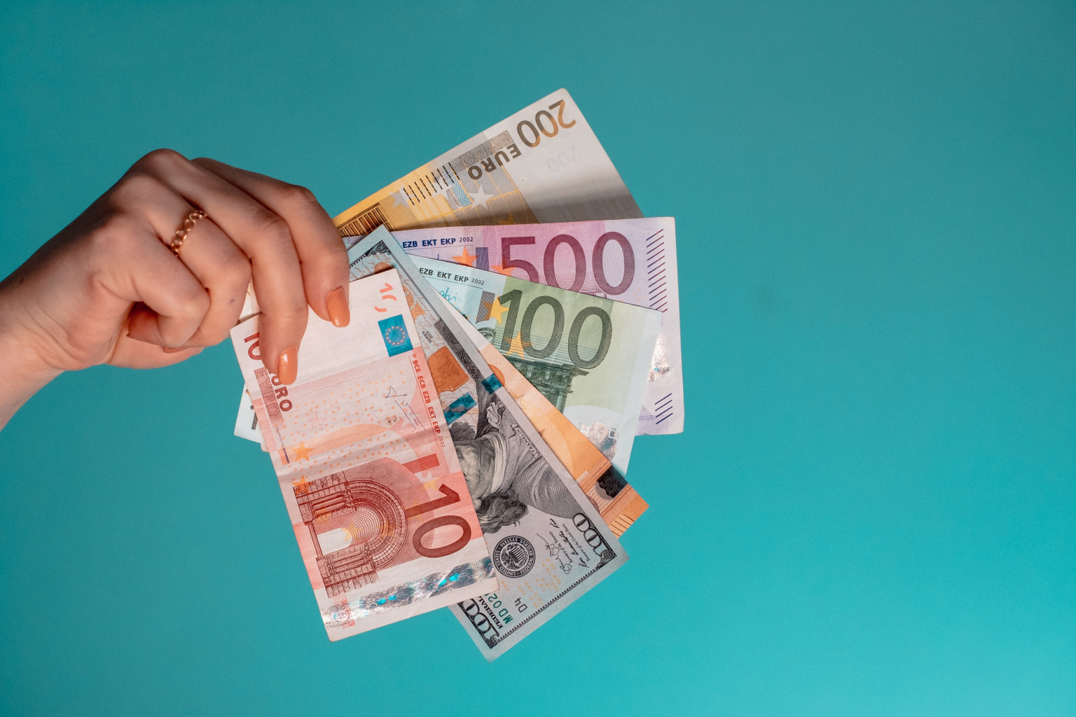 Eine Hand hält Geld aufgefächert vor die Kamera
