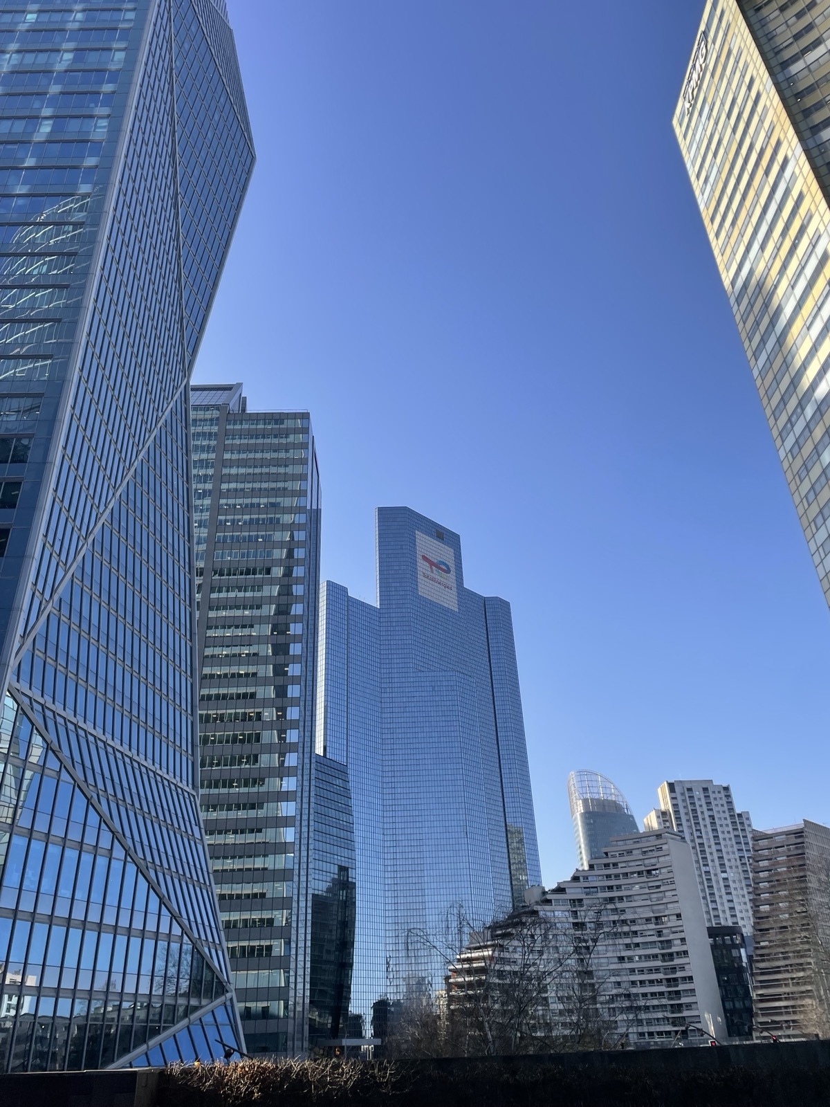 ein Foto von einigen Hochhäusern, deren Glasfassaden den blauen Himmel reflektieren